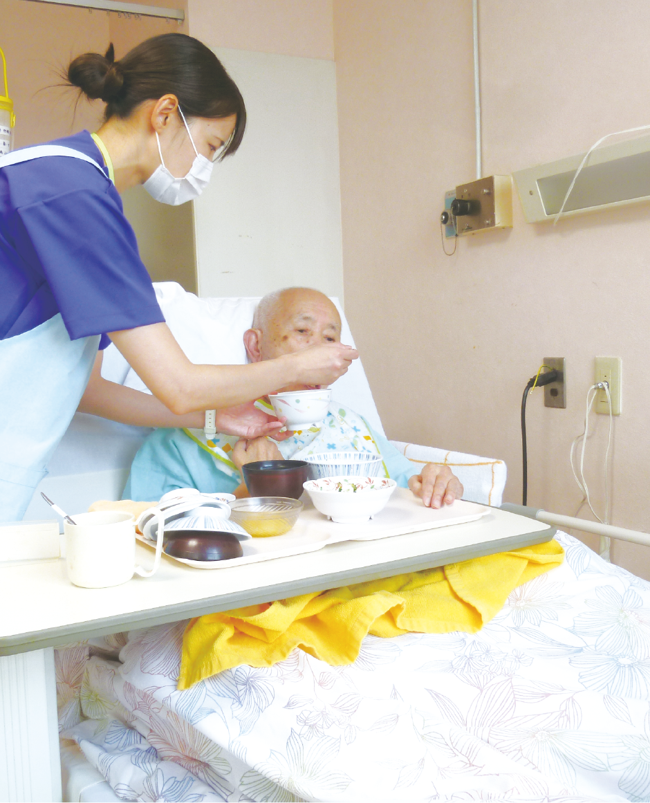 入所者様の食事を介助するスタッフ
